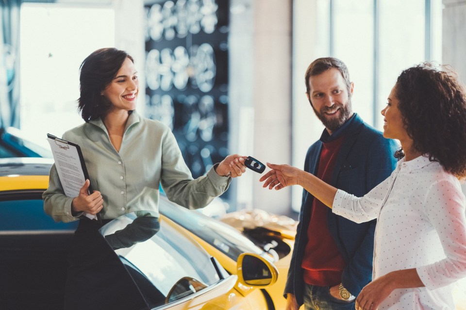 Young man surprising his wife with buying a new car