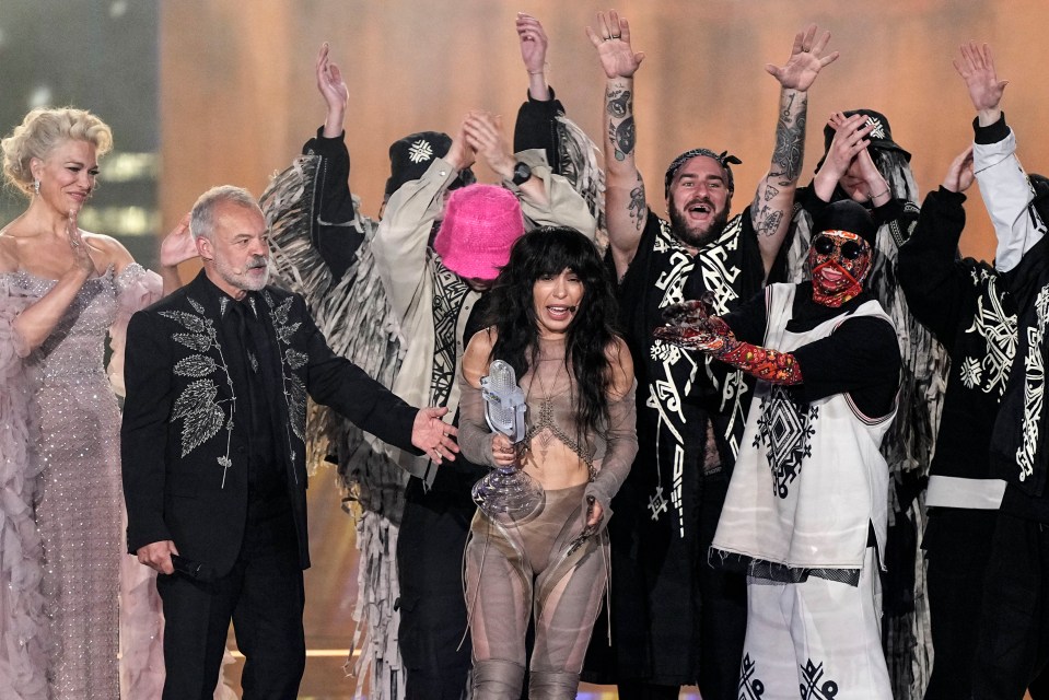 Eurovision winner Loreen of Sweden holds the trophy beside show hosts Hannah Waddingham and Graham Norton