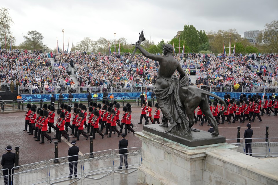 Coldstream Guards march in front of Buckingham Palace as waiting crowds watch on