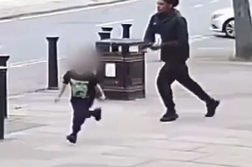 Moments later, as a child walks in his path, the gunman pulls a handgun from the bag