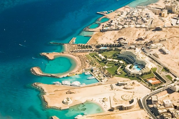 an aerial view of a beach resort with a large building in the middle