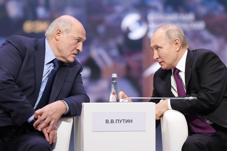 two men sit at a table with a sign that says v.b.putin