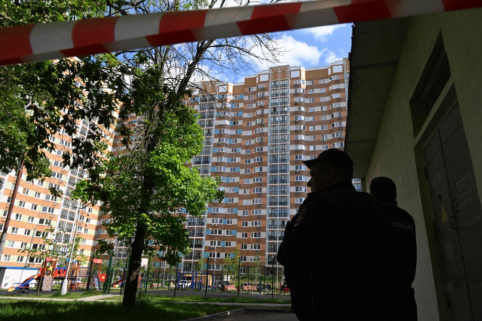 Police officers outside an apartment building after a drone attack in Moscow