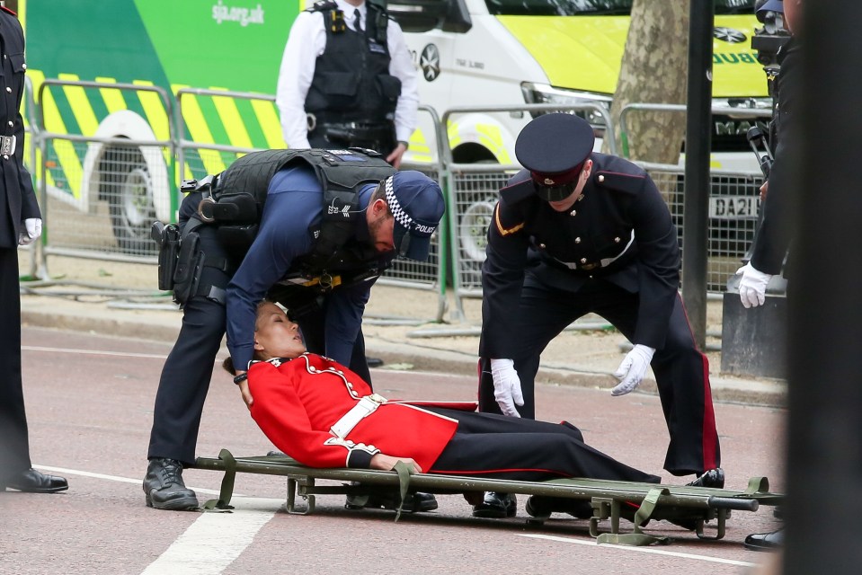 Police officers and paramedics assisted a female solider who fainted on The Mall during the procession