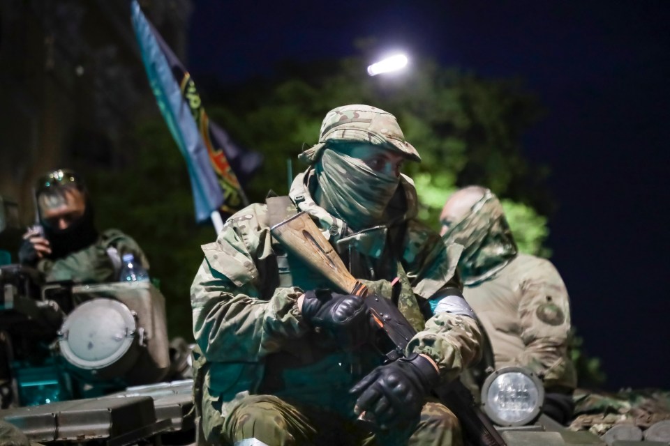 Wagner Group troops sit on top of their trucks in Rostov