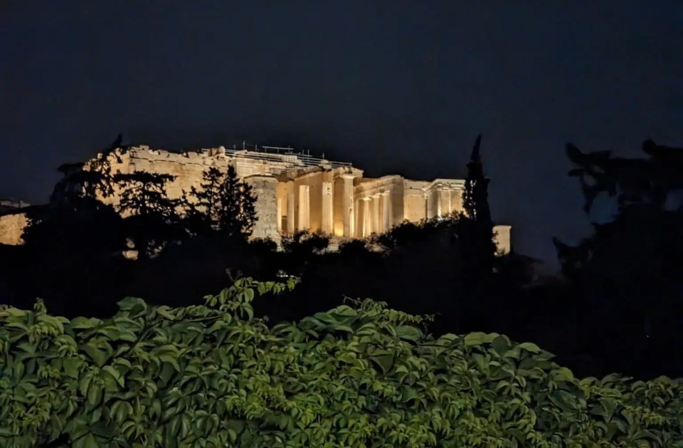 The Acropolis is lit up at night and dominates the skyline around the cinema