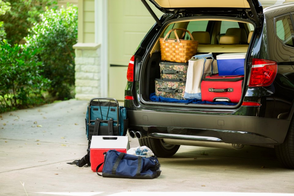 Family sport utility vehicle packed up and ready to go on summer road trip or vacation. Outside house.