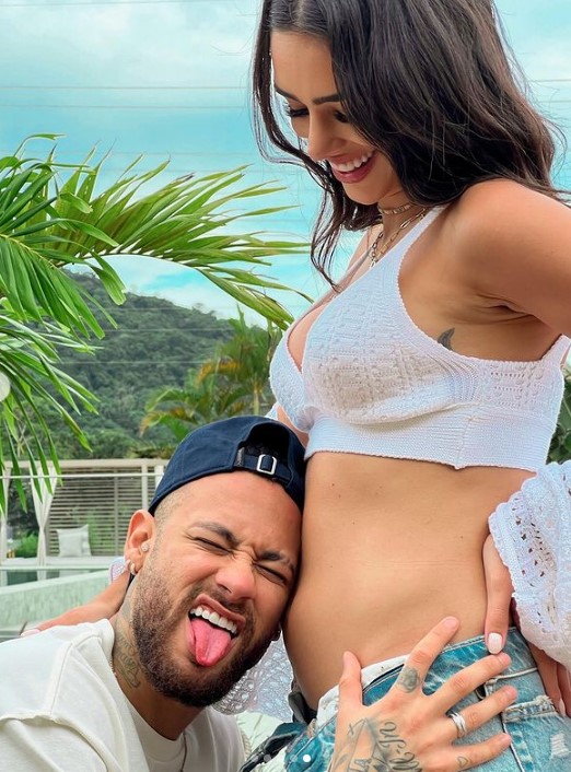 Neymar sticks his tongue out next to his partners' baby bump