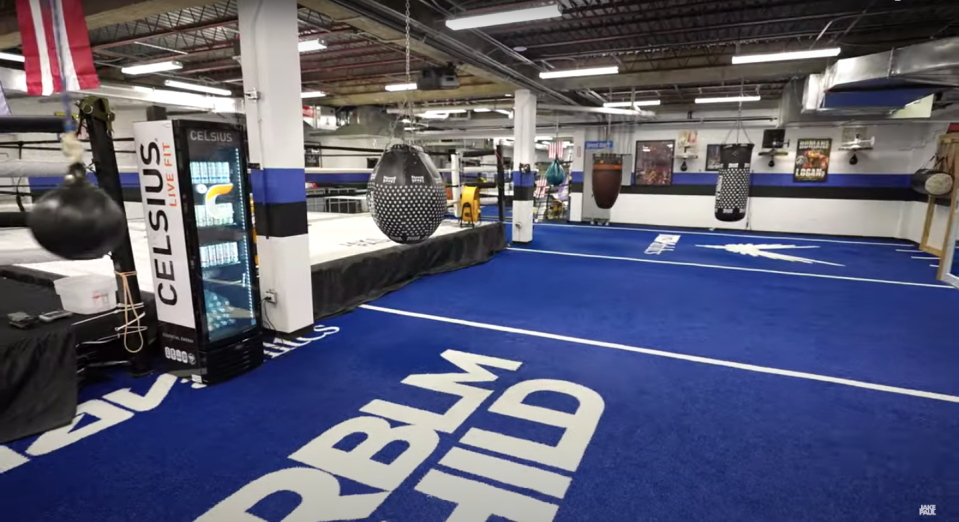 Interior of a boxing gym with boxing equipment and a Celsius LiveFit cooler.