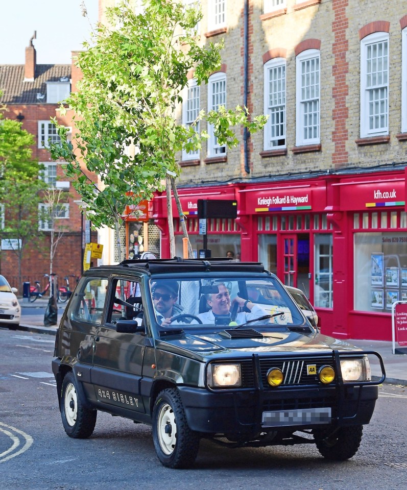 Dominic Cooper risks getting three points on his licence – as he drives his car with two tall saplings sticking out of the sunroof