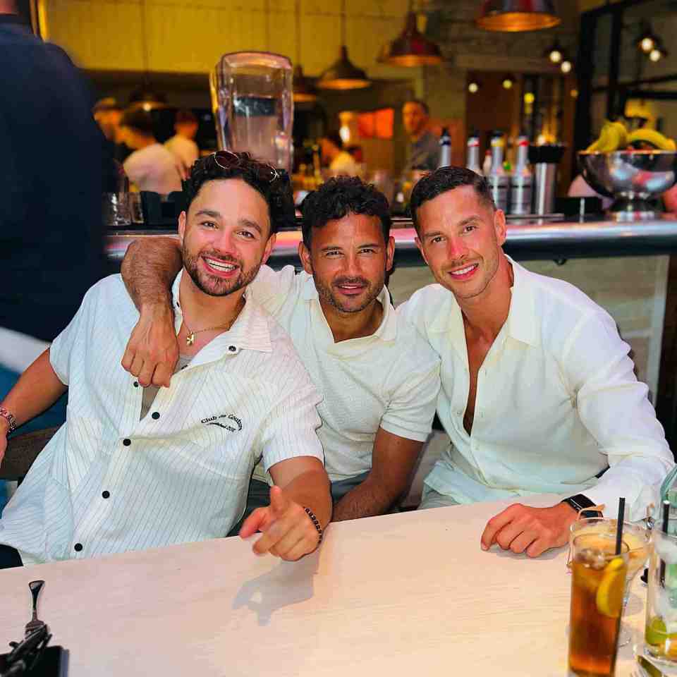 Three men sitting together at a table.