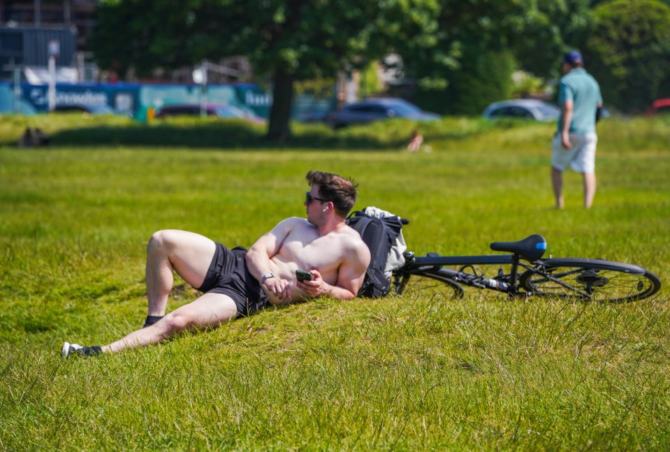 A man sunbathes on Wimbledon common as the Met Office issued the first heat-health alert of the year in six regions in England