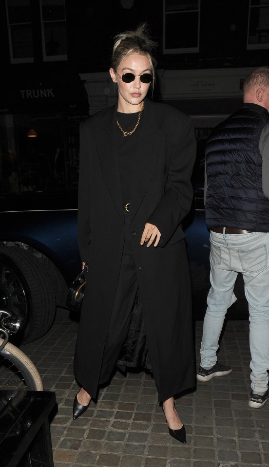 Gigi opted for black trousers, a top and long coat