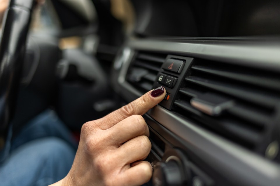 Woman adjusting interior temperature while driving on the road