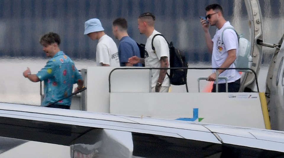 Grealish and the lads depart the plane as they arrive back in Manchester