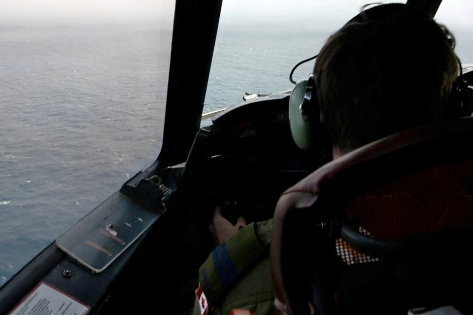 The pilot of a Royal Canadian Air Force CP-140 Aurora maritime surveillance aircraft of 14 Wing flies a search pattern for the missing