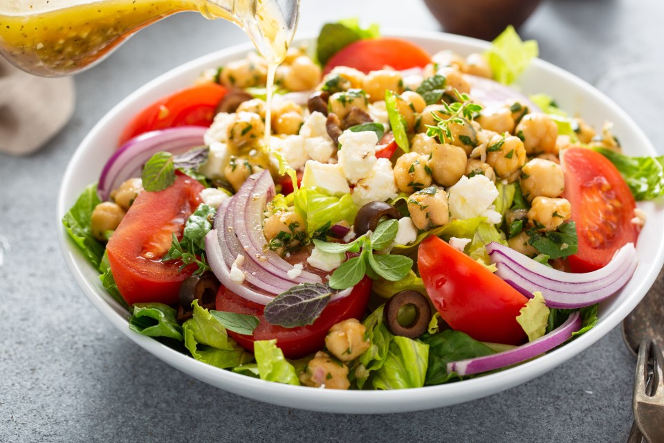 Healthy spring Greek salad with fresh vegetables and seasoned chickpeas drizzled with dressing; Shutterstock ID 1974508607; purchase_order: -; job: -; client: -; other: -