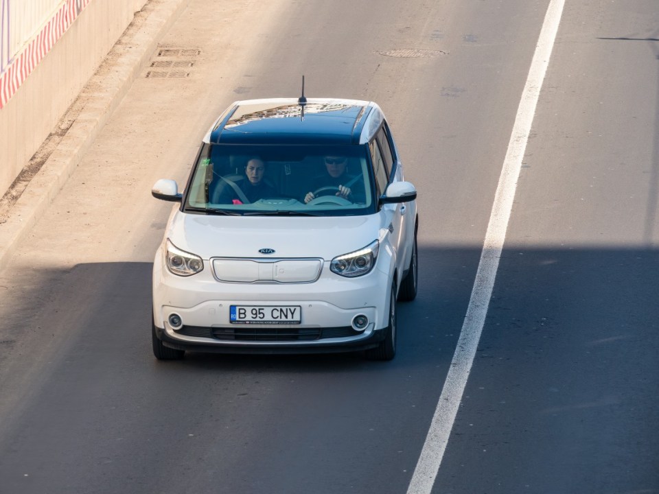 Bucharest, Romania - 03.13.2021: A Kia Soul EV white car in traffic on the streets of Bucharest.