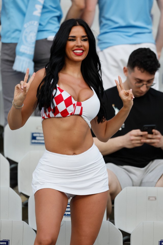 a woman in a bikini giving a peace sign