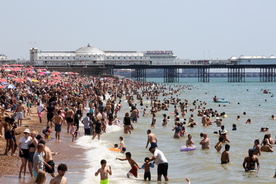 Families enjoying the sun on the beach in Brighton, East Sussex