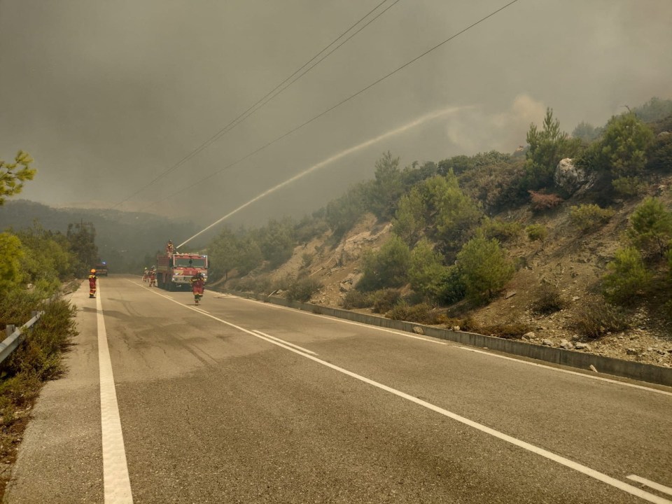 Firefighters try to extinguish a wildfire burning near Kiotari and Lardo