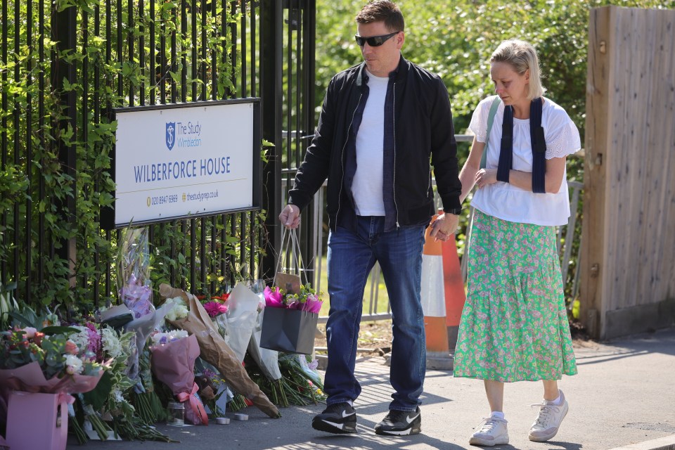 A woman with her arm in a sling leaves flowers outside The Study Prep school