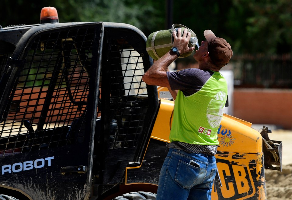 A workman drinks water in the Spanish city of Sevilla to cool down