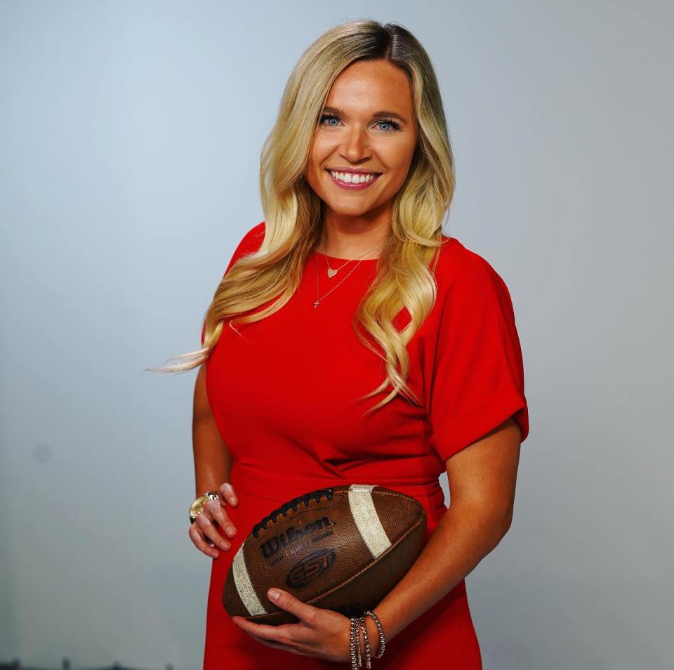 a woman in a red dress is holding a wilson football