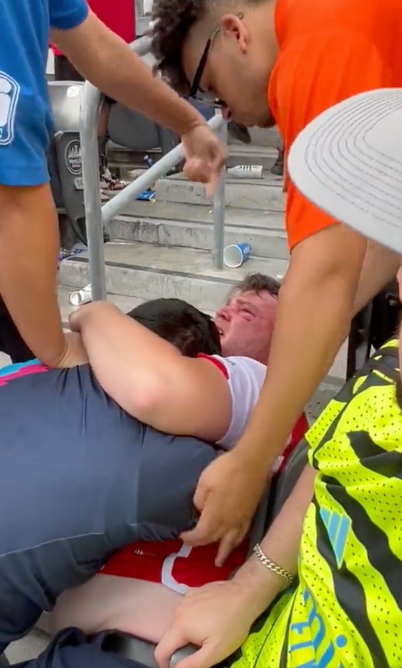 Arsenal fans grapple on the stairs