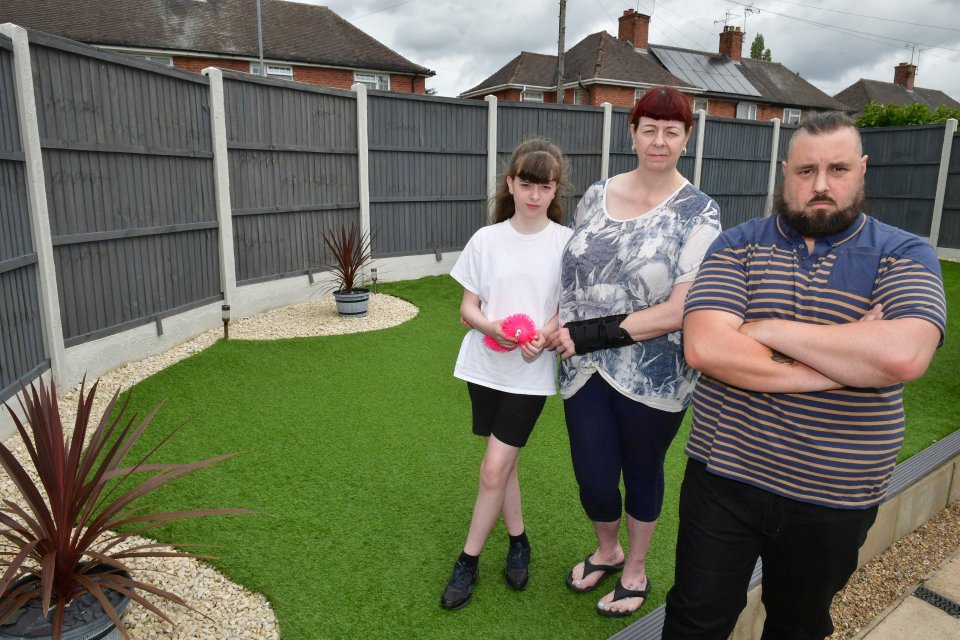 The family with their fence that the council has ordered to be removed