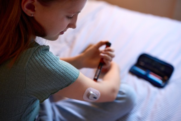 a woman is getting an insulin shot in her arm