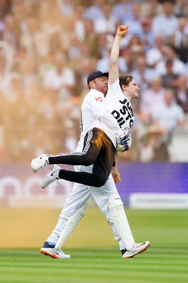 England wicket-keeper Jonny Bairstow carries one of the protesters from the Lords pitch during The Ashes