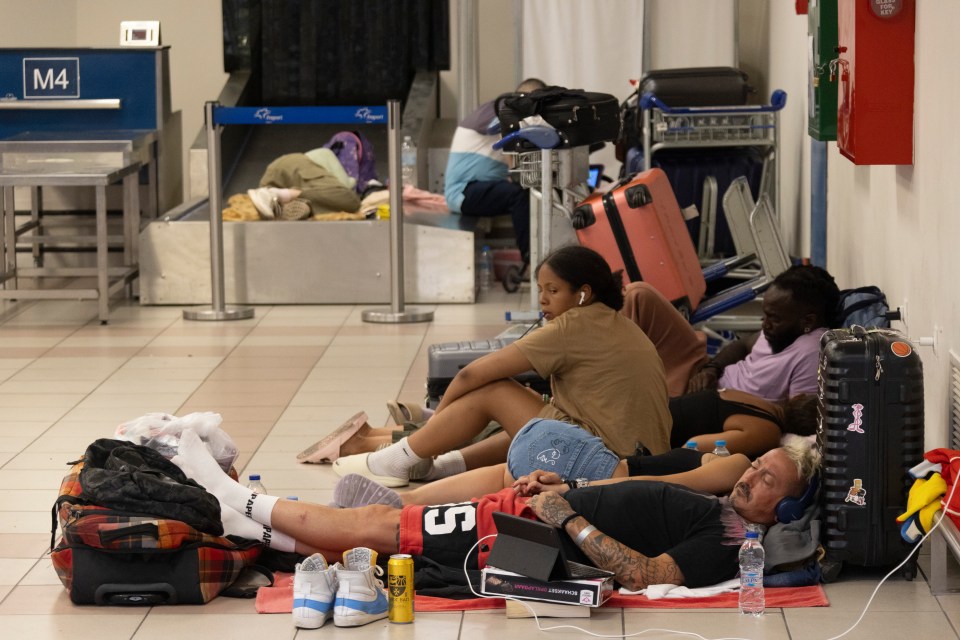 Holidaymakers sleep on the floor at Rhodes airport waiting to be evacuated off the island