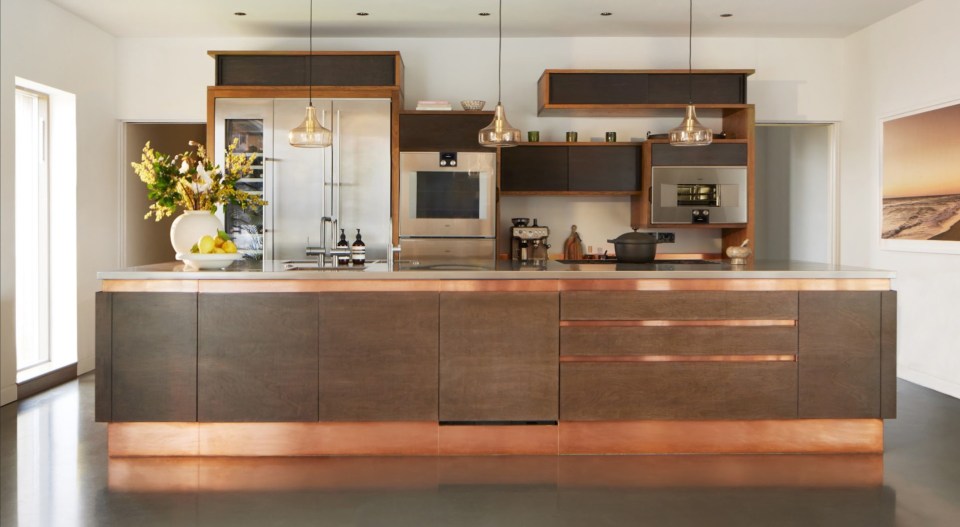 The open-plan kitchen has a coppery finish