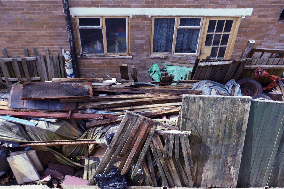 The back garden of Glynis Sheard's neighbour is piled high with rubbish