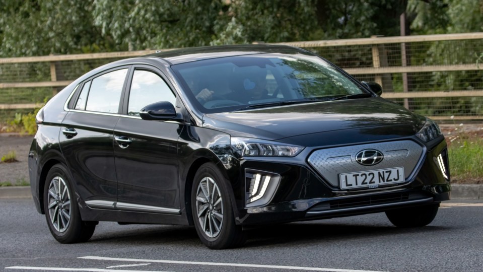 Milton Keynes,UK - June 24th 2023. 2022 black HYUNDAI IONIQ PREMIUM EV electric car travelling on an English country road