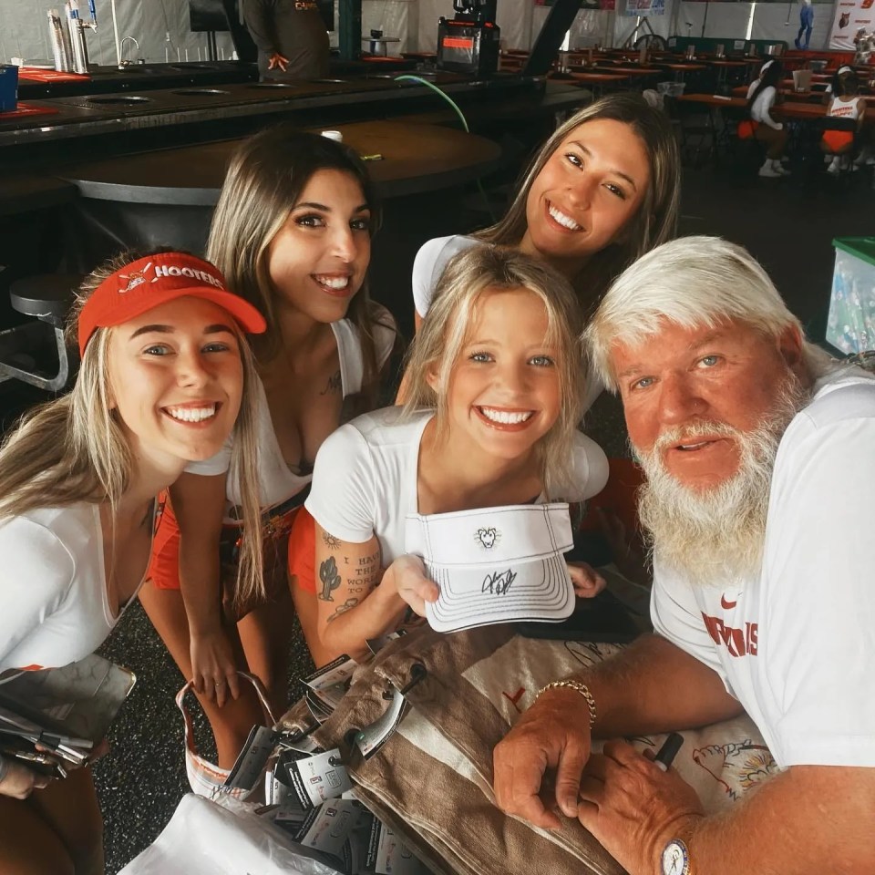 John Daly poses with Hooters waitresses