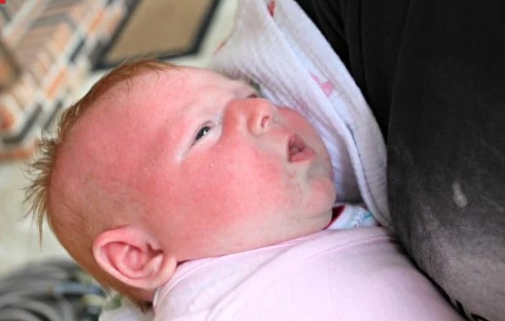 The five-week-old was asleep by the pool, covered by a sun umbrella