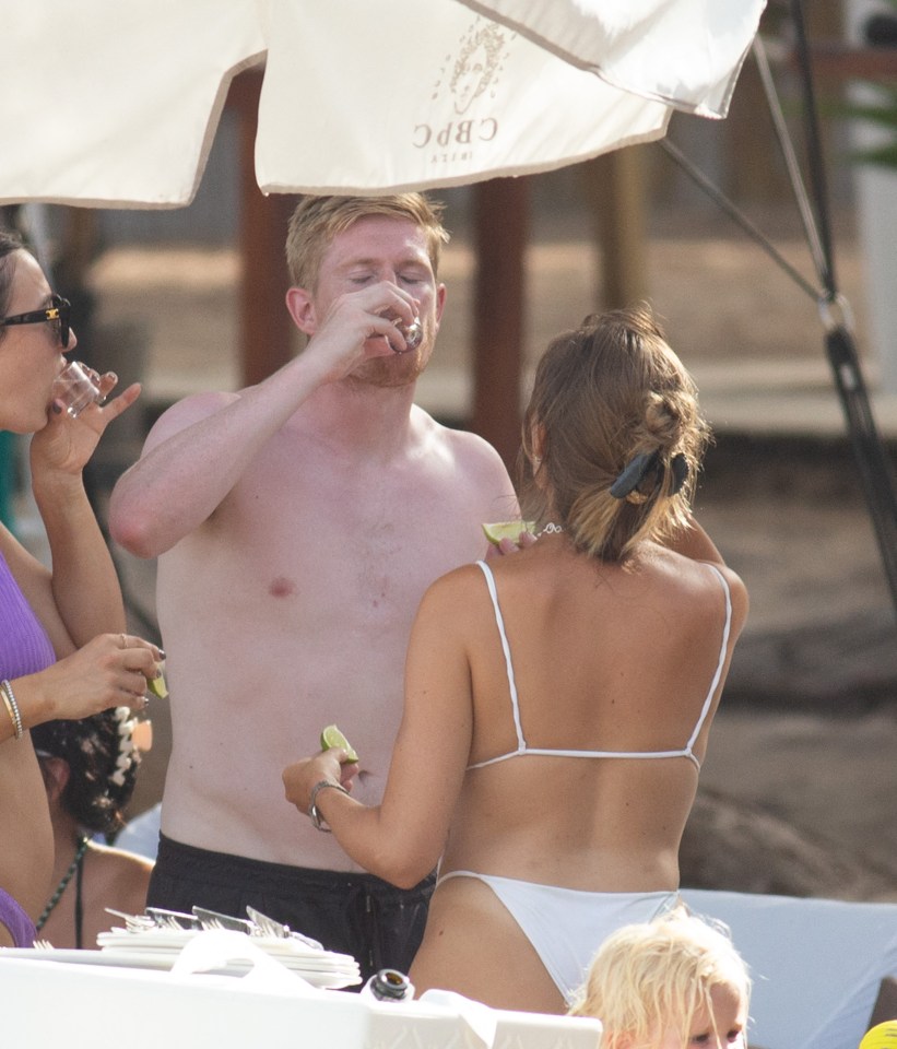 Kevin De Bruyne and Michele Lacroix knocked back a shot at a beach club