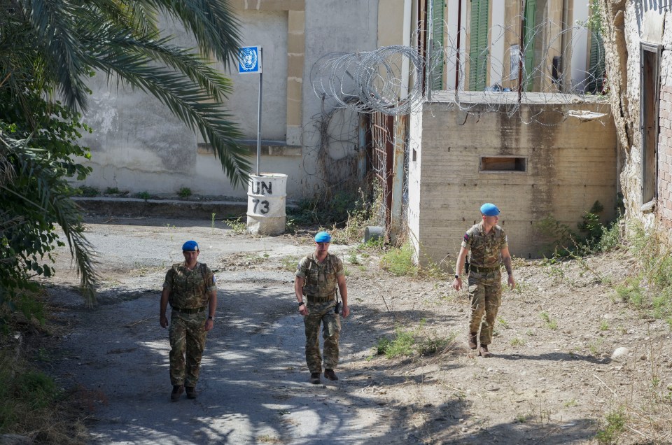 three soldiers walking in front of a sign that says un 73