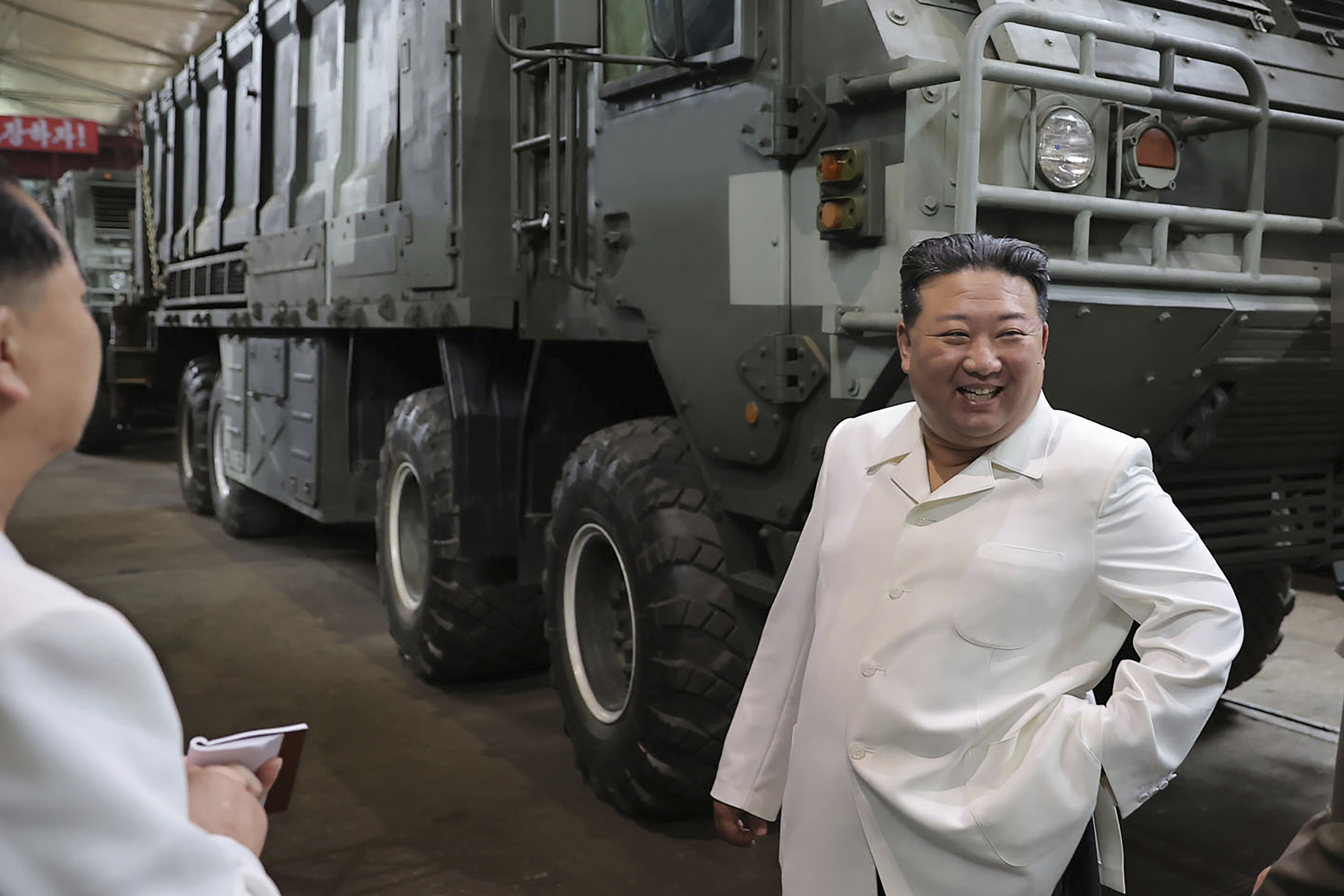 Kim Jong Un, right, smiles during a visit to a military factory in North Korea