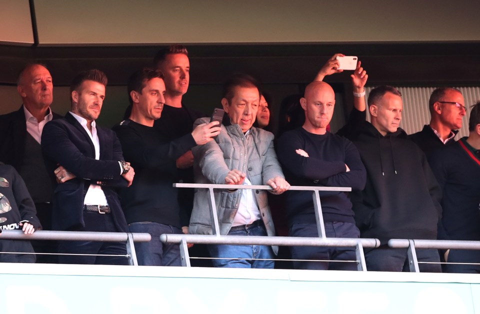 Salford City owners David Beckham, Gary Neville, Peter Lim, Nicky Butt, and Ryan Giggs in the stands at a soccer match.