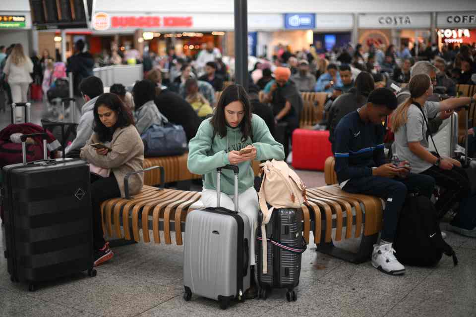 Passengers wait at Stansted Airport, north of London after UK flights were delayed