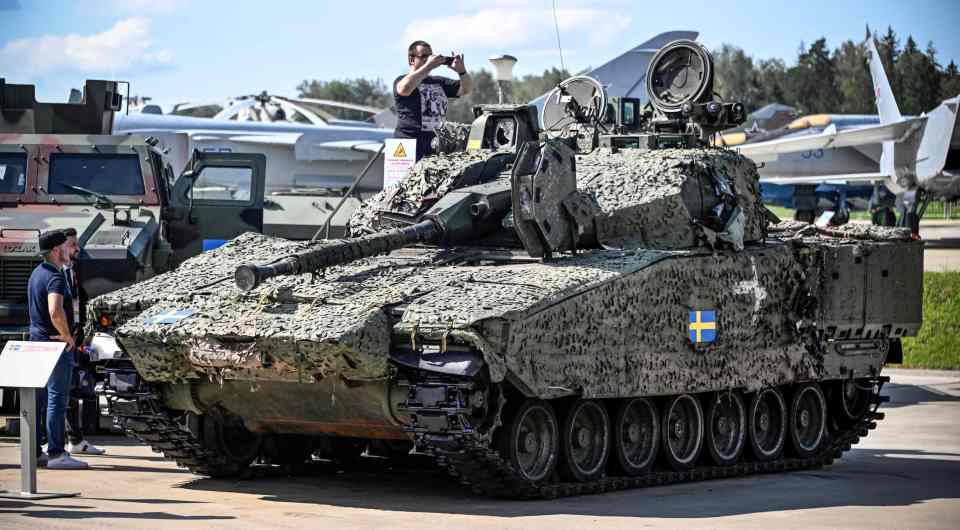 Visitors taking photos of a Swedish CV9040 armoured fighting vehicle