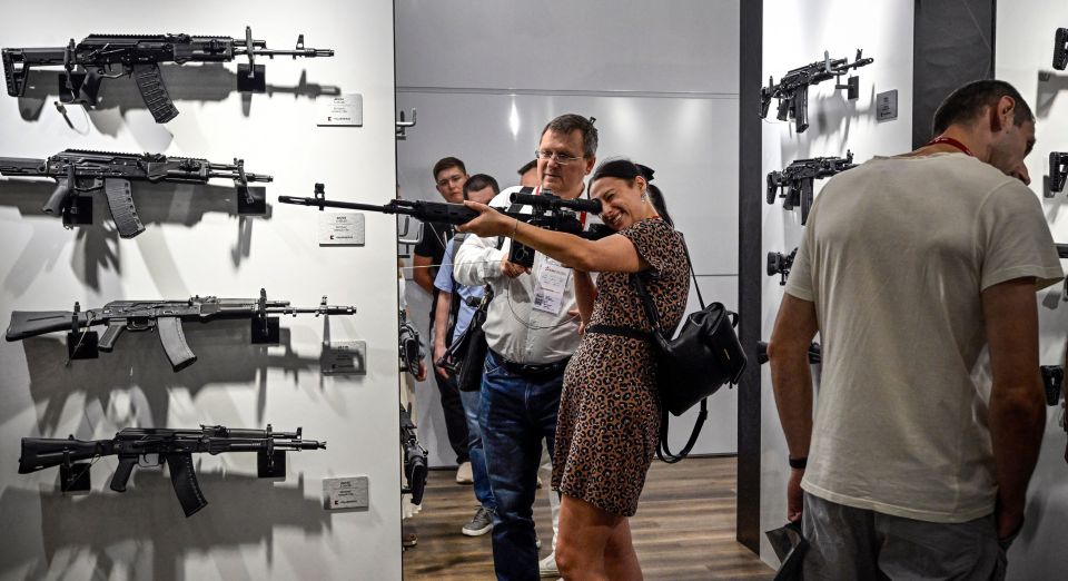 Visitors inspect firearms made by Russian weapons manufacturer Kalashnikov