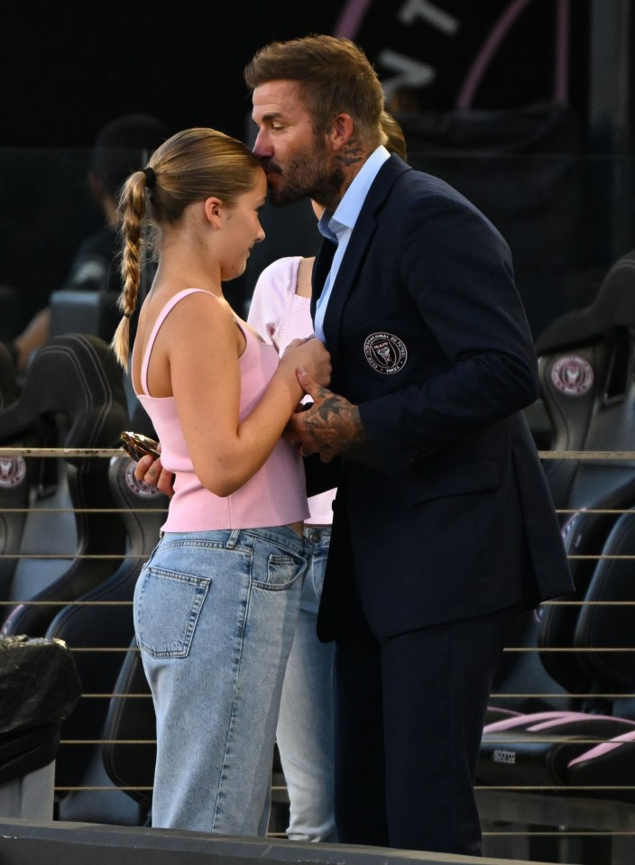 Proud dad David plants a kiss on Harper's head at the game