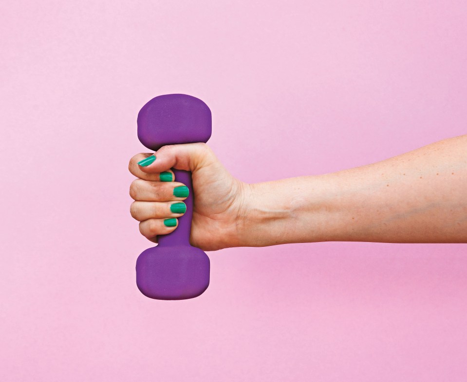 studio image of arm lifting colourful weight against a pink background