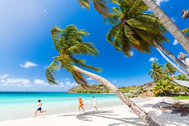 Happy little boy with family running on tropical beach, Antigua, Leeward Islands, Caribbean, West Indies