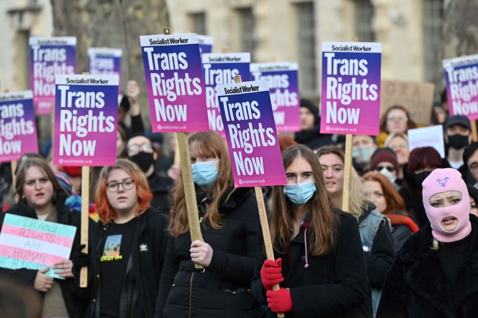 Demonstrators hold placards as they take part in a protest march for trans rights and to show their support for the Scottish gender reform bill, in central London, on January 21, 2022. - The UK government denied on January 17 it was dismantling Scottish self-rule after exercising an unprecedented veto to block a new law passed already by the Edinburgh parliament. The legislation would make it easier for people to self-identify as transgender in Scotland, without the need for a medical diagnosis, and lower the qualifying age from 18 to 16. (Photo by JUSTIN TALLIS / AFP) (Photo by JUSTIN TALLIS/AFP via Getty Images)