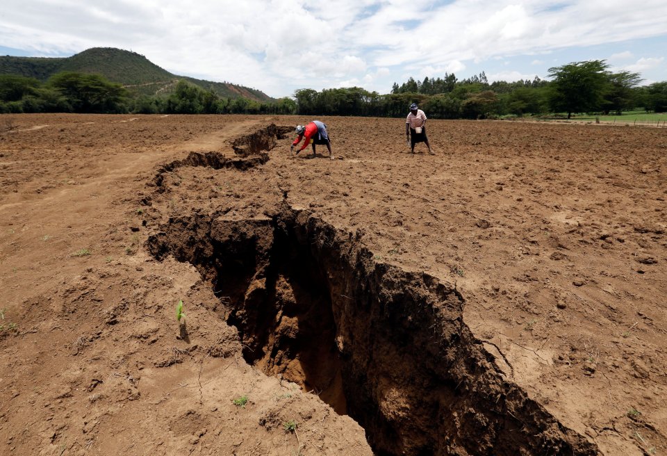 Women work on their farm near a chasm suspected to have been caused by a heavy downpour along an underground fault-line near the Rift Valley town of Mai Mahiu, Kenya March 28, 2018. Picture taken March 28, 2018. REUTERS/Thomas Mukoya